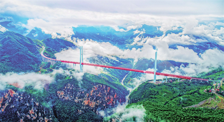 图为目前世界第一高、第二大跨径的钢桁梁斜拉桥北盘江大桥，跨越云贵两省交界的北盘江大峡谷，桥面至江面垂直距离相当于200层楼的高度。贵州省公路工程集团有限公司供图.png